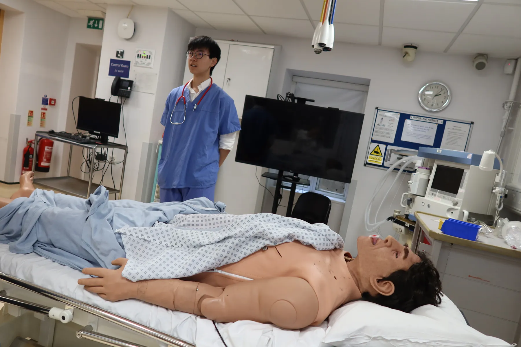 A doctor teaching a student on a simulation patient