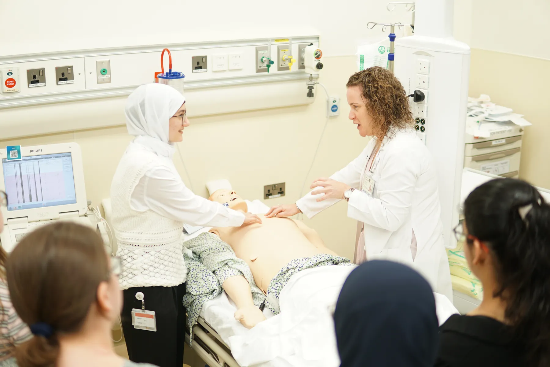 A doctor teaching students on a simulation manikin