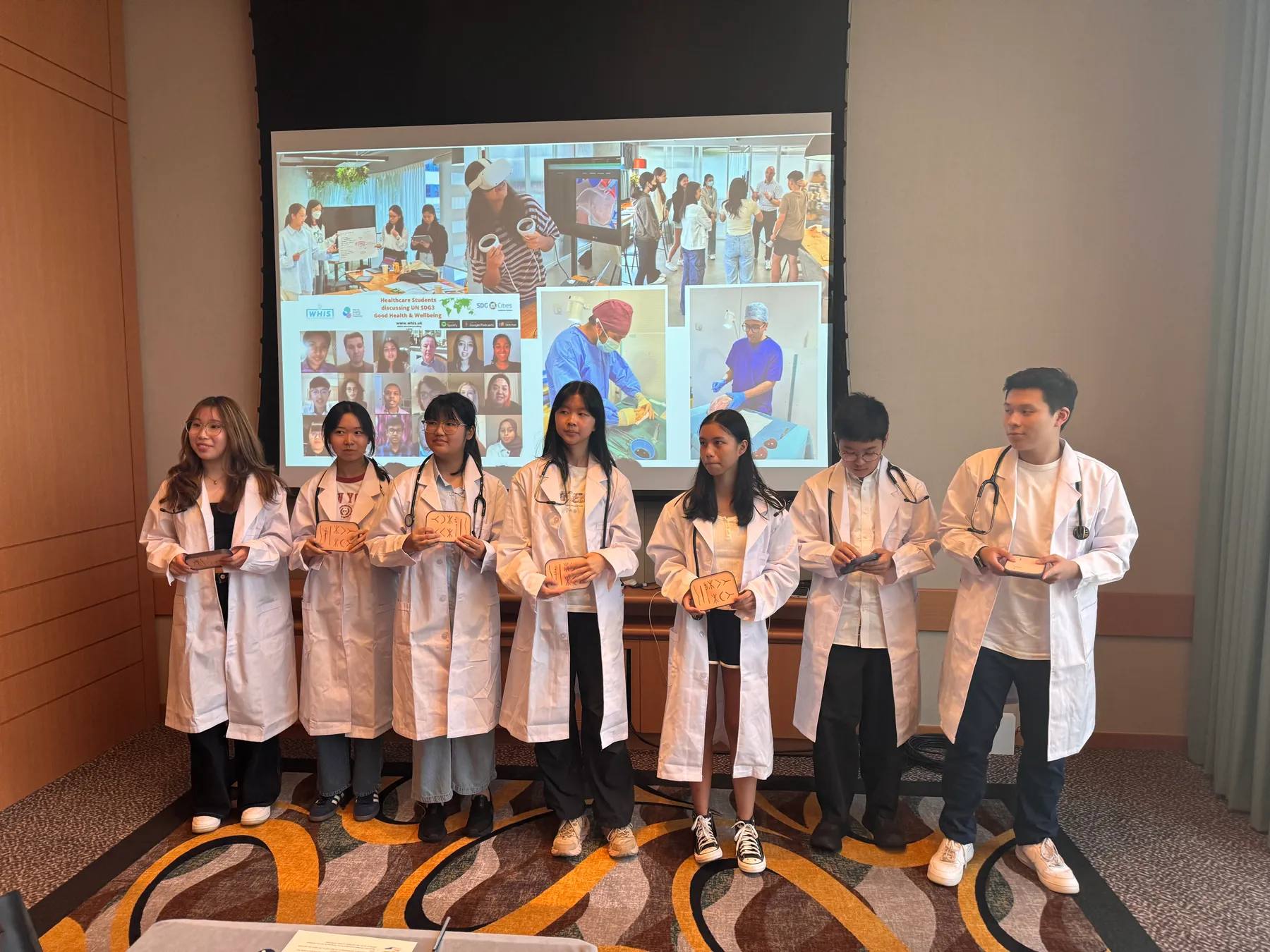 Medefine students in white coats at a widening access event